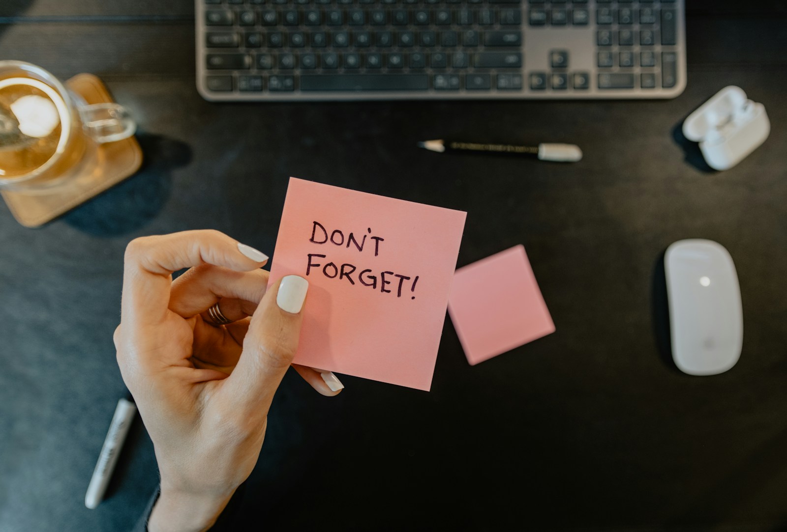 Person holding a note that says “Don’t forget” — illustrating brain fog, a cognitive symptom in perimenopause.